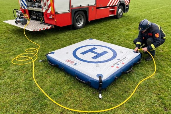 Brandweerman blaast de drone landing pad op met een compressor