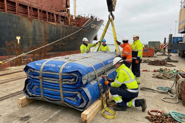 The inflatable rain cover folded onto a pallet, rigged for the lift
