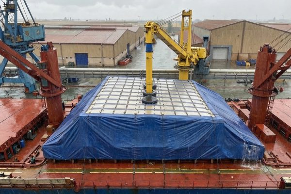 Inflatable rain cover inflated over the hatch of a bulk carrier during loading in the rain