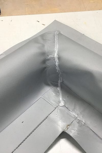 Détail d'un angle soudé dans une barrière anti-déversement franchissable et flexible