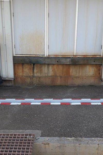 Seuil de rétention de liquides en forme de U autour d'un poste de remplissage contre la façade